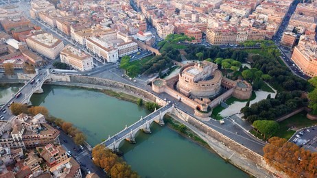 aerial drone view of iconic castel sant'angelo (castle of holy angel) and ponte or bridge sant'angelo with statues in river of tiber next to famous vatican, rome, italy