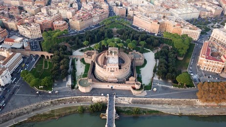 aerial drone view of iconic castel sant'angelo (castle of holy angel) and ponte or bridge sant'angelo with statues in river of tiber next to famous vatican, rome, italy