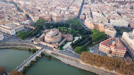 aerial drone view of iconic castel sant'angelo (castle of holy angel) and ponte or bridge sant'angelo with statues in river of tiber next to famous vatican, rome, italy