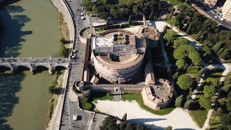 aerial drone view of iconic castel sant'angelo (castle of holy angel) and ponte or bridge sant'angelo with statues in river of tiber next to famous vatican, rome, italy