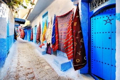 moroccan handmade crafts, carpets and bags hanging in the narrow street of essaouira in morocco with selective focus