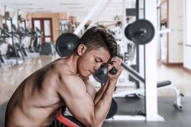 side view of asian man doing exercise with a weight machine in the gym center