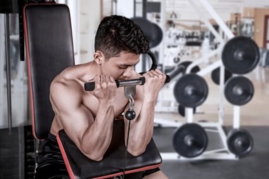picture of a young man exercising with a weight machine in the gym center