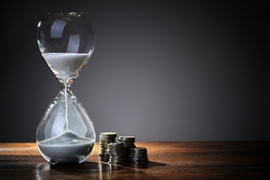 deadline and time is money concept with hourglass and british coin currency