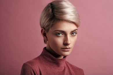 portrait of fashion woman with blond short hair isolated on pink background