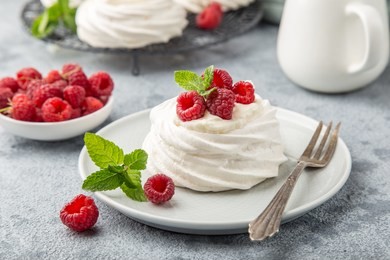 mini pavlova  meringue cakes with whipped cream and fresh raspberry, selective focus