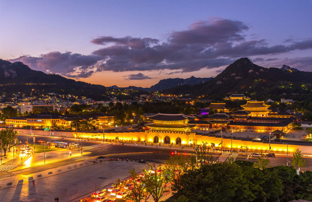 gyeongbokgung palace at night in south korea, with the name of the palace 'gyeongbokgung' on a sign