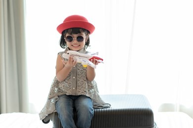 asian child playing with toy airplane. travel, tourism and tourist concept.