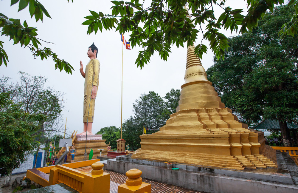 ancient golden pagoda and buddha statue at wat phnom yat, pailin province, cambodia, the temple built by shan migrants from myanmar in 1922. shallow dept of field. the temple is open to the public.