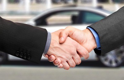 business handshake to close the deal after buying a car