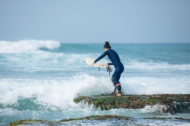 woman surfer with surfboard going to surf the big waves