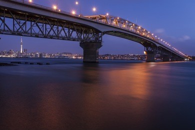 auckland harbor bridge/ auckland's iconic harbor bridge with the city in the background