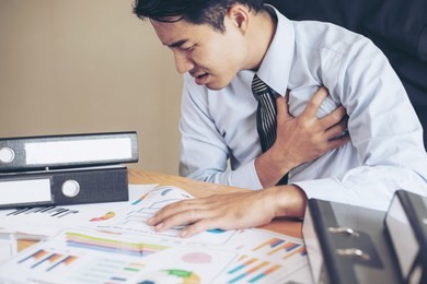 business man asian suffering from pain in his chest heart attack on office desk -  business person heart disease
