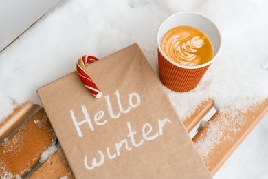 hello winter, snowy background, christmas candi canes, cup of coffee, winter book.