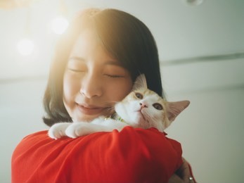 cute asian woman holding her kitty at home.