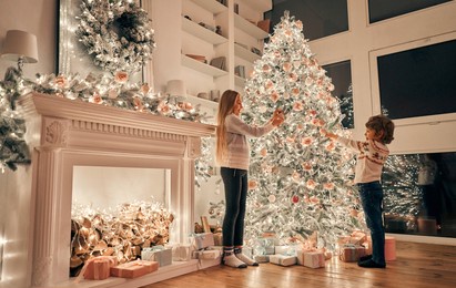 the little girl and boy decorating the christmas tree