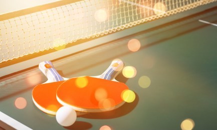 table tennis rackets and ball on table with net