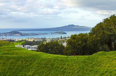 panoramic view from mt eden crater looking to rangitoto island & volcano, auckland new zealand; afternoon time before sunset