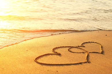 hearts drawn on the sand of a beach