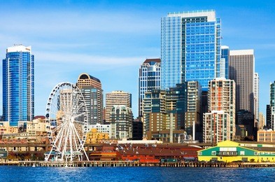 seattle skyline and waterfront including the ferris wheel and sparkling high rise downtown buildings viewed from the bay on a bright clear day.