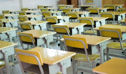 desk and chairs in classroom.