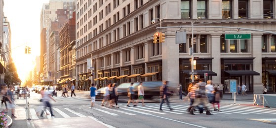 new york city street scene with crowds of people walking through the busy intersection of 23rd and 5th avenue in midtown manhattan