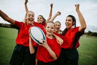 cheerful female rugby players celebrating