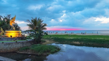 sunset above naka snake sculpture at karon beach naka god of snake statue in the middle of karon beach phuket.naga statue is a landmark of karon beach and a superstitious belief in protect the people