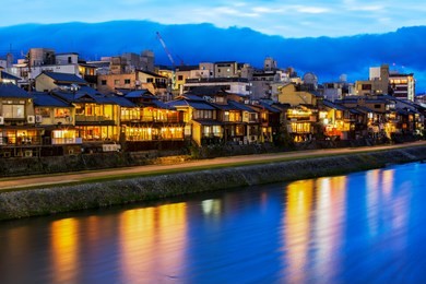 night view on the kamogawa river embankment in kyoto. restaurant lights reflected in the river.