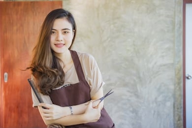 professional woman hairdresser in salon with scissors in hand.