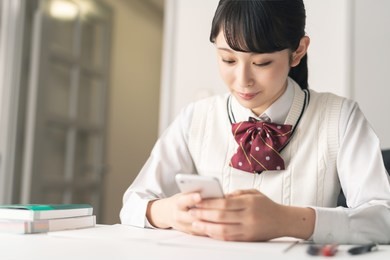 asian school girl using a smart phone.