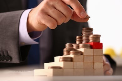 hand businessman putting pin money financial pyramid tower. future needs loan education or mortgage credit spend vacation of dream effective buying financial risk and safety concept