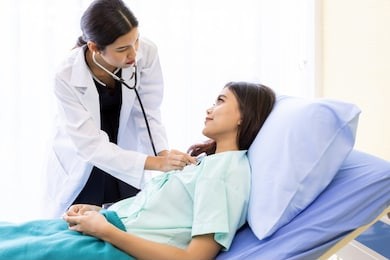 asian doctor make routine health check with patient in hospital ward