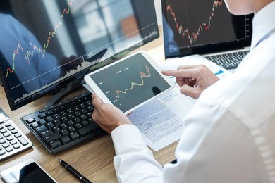 stock exchange market concept, stock broker looking at graph working and analyzing with display screen, pointing on the data presented and deal on a exchange, businessman trading stocks online.