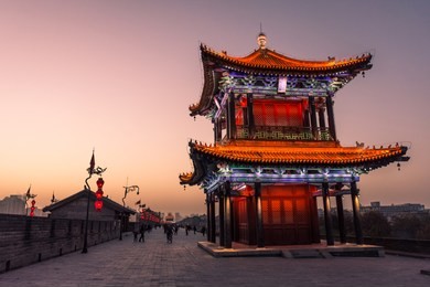 beautiful illuminated traditional chinese temple on the xi'an city walls at evening, china