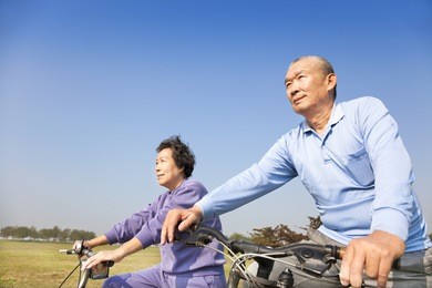 happy elderly seniors couple biking
