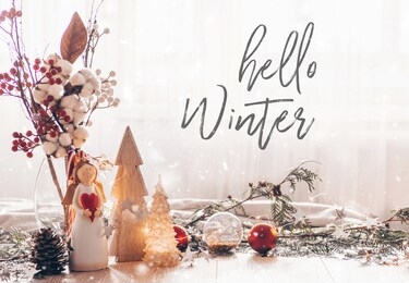 ready to postcard hello winter.  christmas festive decor still life on wooden background, christmas decor warm sweater and led string lights, christmas tree. concept of home comfort and holiday