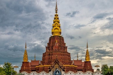 landscape view of central dai temple and stupas in jinghong china. red brick theravada buddhist temple with gold towers. (xishuangbanna, yunnan province, china).