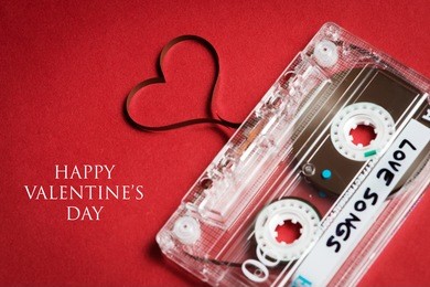 valentines day card - audio cassette with magnetic tape in shape of heart on red background