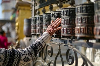 woman walking around prayer wheels at swayambhunath stupa