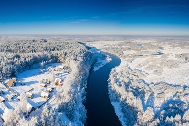 aerial winter landscape. river with snowy riversides view from above. belarus winter landscape.