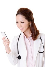 friendly asian doctor woman check message on cellphone, closeup portrait isolated on white background.