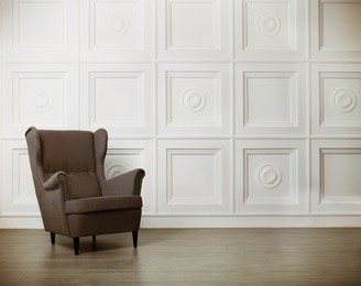 one classic armchair against a white wall and floor. copy space