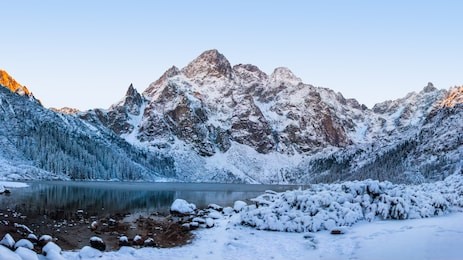 morskie oko lake in tatra mountains. winter nature. winter mountain. clear morning in tatra national park. sunrise in sea eye lake. snowy hillsides and icy lake