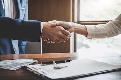 real estate agent and customers shaking hands together celebrating finished contract after about home insurance and investment loan, handshake and successful deal.