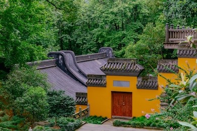 buildings with yellow wall, red door, and black roof tiles in lingyin temple, hangzhou, china