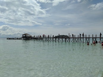 beautiful ocean scene with a serene peaceful dock and boats off of kota kinabalu in malaysia landscape background 
