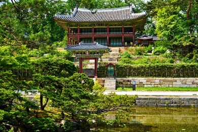 view of secret garden of changdeokgung palace in seoul, korea. 
 the meaning of the two non-english texts are: upper one, 'pavilion of uniting the universe', and lower one, 'gate of fish in the water'