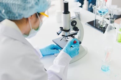 asian scientists are preparing a microscope for laboratory testing and analysis. science and chemical concepts.