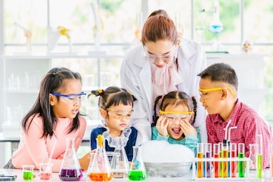 science teacher teach asian students in laboratory room, smoke float out of bowl, they excited, colorful test tube and microscope on table in laboratory room, concept for study in laboratory room.